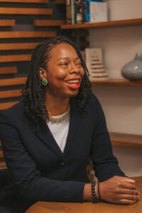 Etinosa Agbonlahor sitting on her office while she talks about ways to talk to your parents about money.